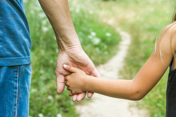  parent holds the hand of a small child