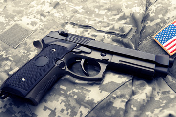 Handgun over American solder's uniform with shoulder patch on it
