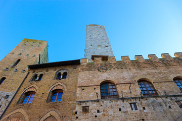Medieval houses and tower of San Gimignano, Tuscany, Italy with blue winter sky on the background 