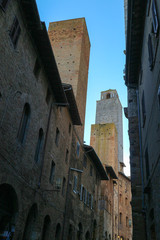 View to Torre Grosso (Big tower) from narrow street of San Gimignano, Tuscany, Italy