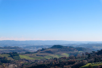 Naklejka premium Winter morning Tuscany landscape with trees and blue sky, San Gimignano, Italy