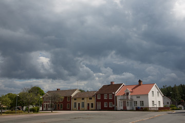 Fototapeta na wymiar Dark clouds above a number of Swedisch houses