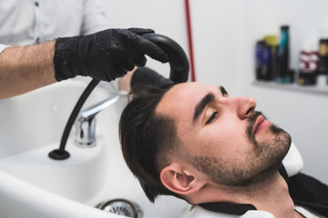 Man having his hair washed  in hairdressing salon