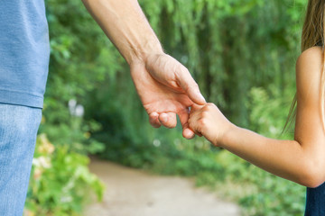 the parent holding the child's hand with a happy background