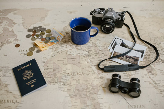 vintage map, film cameras, antique binoculars, coffee, passport and photo prints