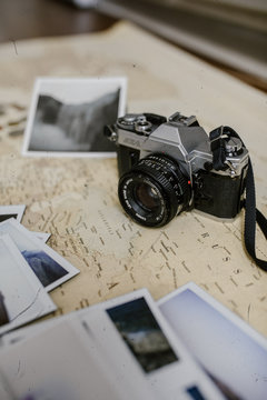 vintage antique film camera on map and photo prints