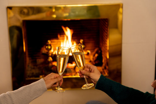 Close Up Of Happy Couple Toasting With Champagne By Fire Place Celebrating Love And Winter Vacation