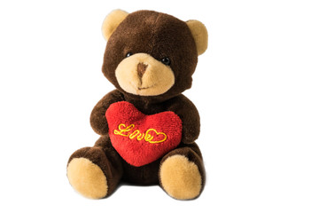 Toy teddy bear with a heart in its paws on a white background.