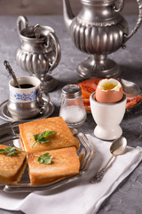 Breakfast with croutons, poached egg and coffee. Vintage dishes.