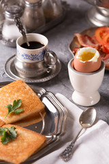 Breakfast with croutons, poached egg and coffee. Vintage dishes.