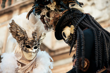 Two women in Venetian carnival masks close up