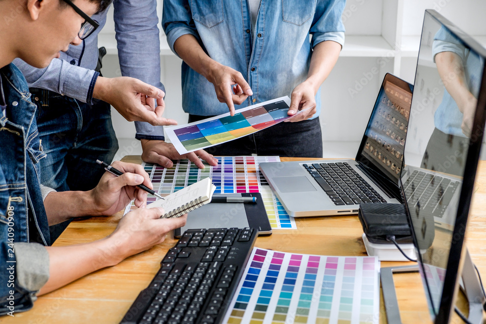 Poster team of young colleagues creative graphic designer working on color selection and drawing on graphic