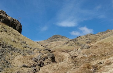 Marshy valley with mountain peaks, rocks, stream and footpath (Lake District)