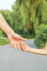 the parent holding the child's hand with a happy background