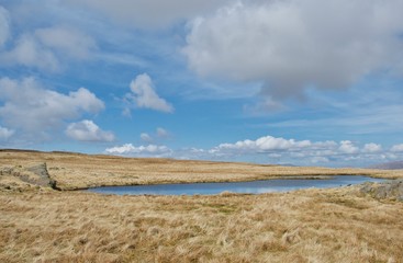 Vivid blue mountain tarn (pool) on top of a fell in the Lake District (Cumbria, UK)