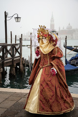 Fototapeta na wymiar Woman in Venetian carnival outfit on the lagoon background
