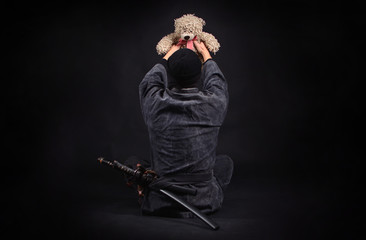 Ninja with teddy bear. Good and strength. Protection of the weak concept. © Dmytro