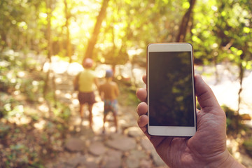 mobile phone in hand in tropical forest