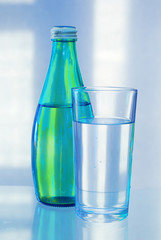 Drinking water in a green bottle and in a glass