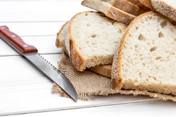 Cutting board with pieces of bread and knife on the table. Close up.