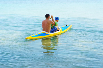 father and son floating in sea