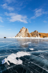 Lake Baikal in winter. The famous Cape Burkhan near the village of Khuzhir and the Shamanka rock is a natural landmark. Tourists travel on the ice by car
