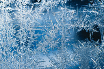 Frosty patterns on the frozen window are macro. Winter background