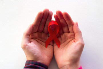 man and woman hold red ribbon close up