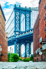 Manhattan Bridge tussen Manhattan en Brooklyn over East River gezien vanuit een smal steegje omsloten door twee bakstenen gebouwen op een zonnige dag in Washington Street in Dumbo, Brooklyn, NYC