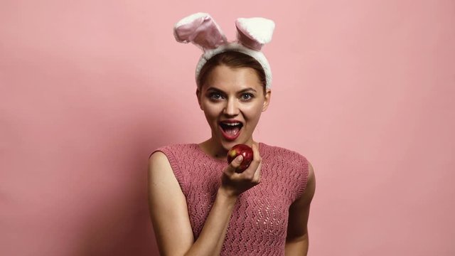 Easter bunny girl on pink background. Happy easter. Beautiful sexy young woman wearing bunny ears on Easter day. Pretty girl preparing for Easter.