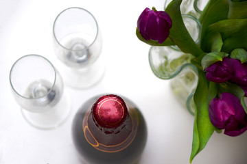 Spring celebrations with fresh purple tulips, bottle of champagne and two glasses