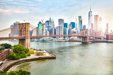 Amazing panorama view of New York city skyline and Brooklyn bridge with skyscrapers and East River flowing during daytime in United States of America