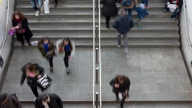 Time lapse of an overhead view of people walking towards and away from the entrance to the underground train station