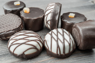 assortment of chocolate sweet candies on wooden background, select focus