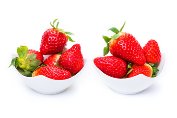 ripe strawberries in white plates on a white background