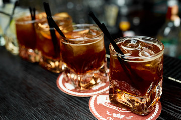 Four alcoholic cocktails whiskey with cola and lemon in glasses 