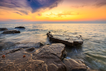 Enjoying the colorful sunset on a beach with rocks on the Adriatic Sea coast Istria Croatia
