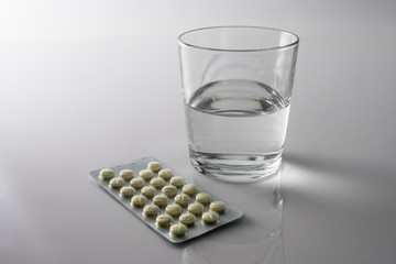 Pills Blister along with a water glass, conceptual image