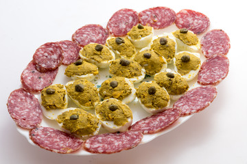 Appetizer with stuffed eggs and sliced salami