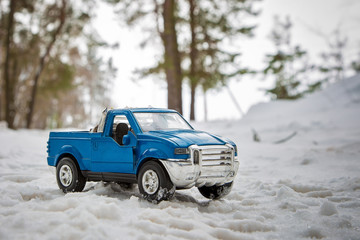 A toy. Blue pickup truck in winter forest on the road. Standing with open door © Dmitry Dven