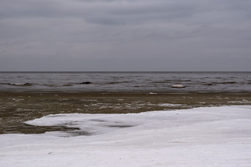 Snowy seashore. View of the horizon, on a cold winter evening.