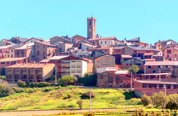Rural village in the north of Spain surrounded by cultivated fields on a sunny day.