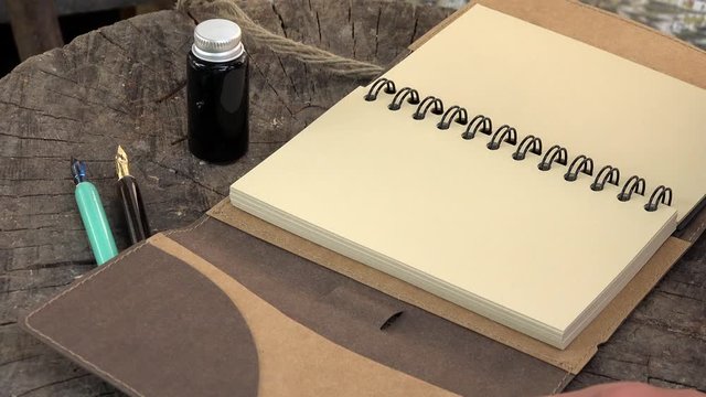 Closing an open agenda with thread, wood vintage fountan pen and ink pot bottle&nbsp;