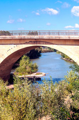 Ancient bridge over a river in France on a sunny day.