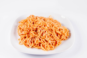 Spaghetti with pesto on a plate on a white background