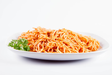 Spaghetti with pesto decorated with parsley on a plate on a white background