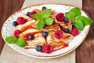 Dessert plate with pancakes, blueberry, raspberry and sweet syrup