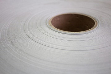 Fototapeta na wymiar Roll of white paper on a cardboard shell