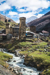 Fototapeta na wymiar Picturesque landscape of aged Georgian rural community Ushguli in valley of beautiful mountains with snowy peaks