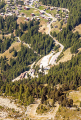 Wooden houses in the meadows of the Swiss Alps in the Saint Luc valley on a sunny day.